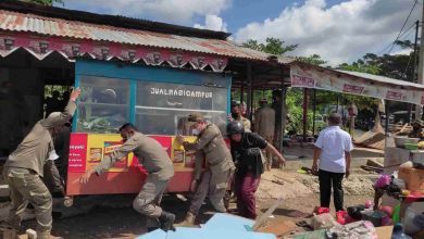 Satpol PP ketika melakukan pembongkaran dan pengangkutan isi rumah pedagang yang berada di atas lahan pemerintah di Polder Air Hitam. (Devi Nila Sari/Akurasi.id)