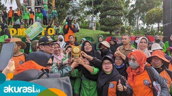 Wali Kota Bontang bersama petugas kebersihan memegang piala Adipura Kencana. (Fajri/Akurasi.id)
