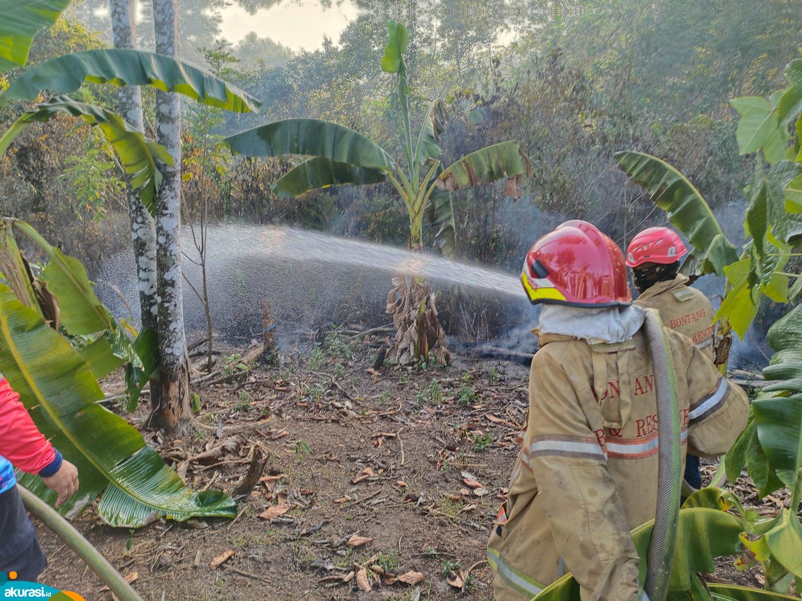 Petugas pemadam kebakaran berupaya memadamkan api yang berlokasi di Jalan Pipa Gang Mulia, yang diduga sengaja dibakar. (Dwi Kurniawan Nugroho / Akurasi. Id)