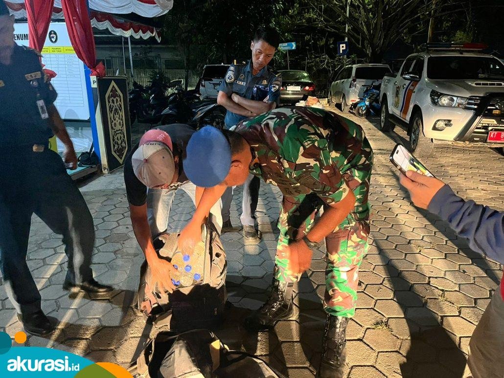 Saat petugas memeriksa dua tas tak bertuan yang ternyata berisi puluhan botol miras ilegal Cap Tikus. (Nugrah/Akurasi.id)