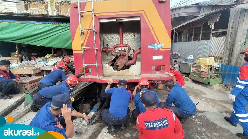 Sulitnya tangani kebakaran gang sempit. Belasan personel Disdamkartan mengevakuasi mobil yang terperosok di parit depan Gang Arwana Satu Jalan KS Tubun. (Dwi Kurniawan Nugroho/akurasi.id)