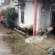 Rumah warga Bontang terendam banjir. Seorang warga sedang menguras air di dalam rumahnya di wilayah RT 27, Kelurahan Bontang Baru. (Dwi Kurniawan Nugroho/Akurasi.id)