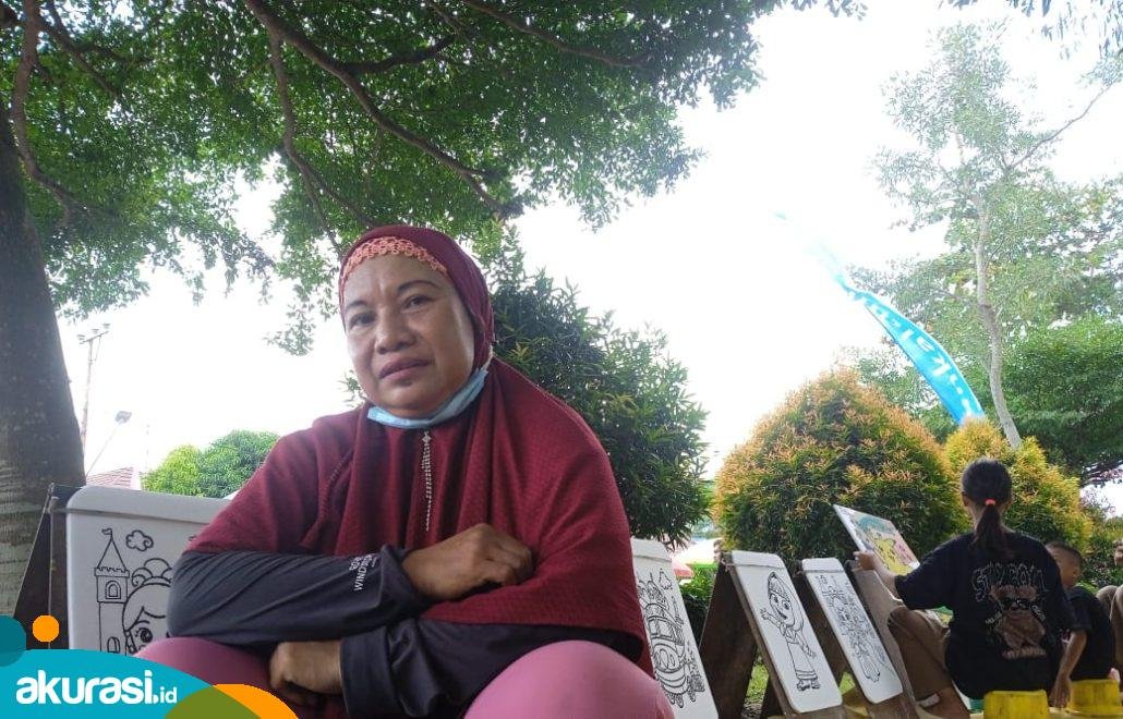 Lili yang sedang menunggui lukisannya di Taman Samarendah, ketika Pawai Pembangunan dalam rangka memperingati HUT ke-79 Republik Indonesia. (Yasinta Erikania Daniartie/Akurasi.id)